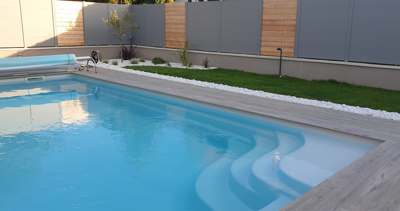 Piscine coque, terrasse carrelée, jardin paysagé, clôture alu/bois Piscine coque, terrasse carrelée, jardin paysagé, clôture alu/bois